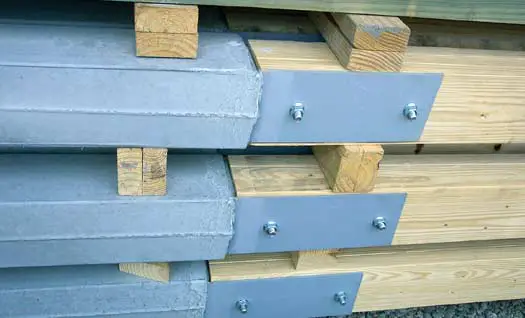 Stacked Perma-Column precast concrete lowers with powder-coated steel brackets bolted to laminated wood columns