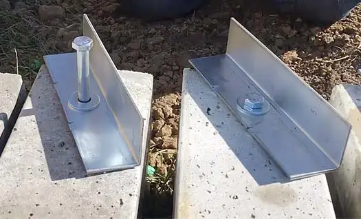 Galvanized Perma-Column uplift anchor brackets bolted to precast concrete columns set in the ground