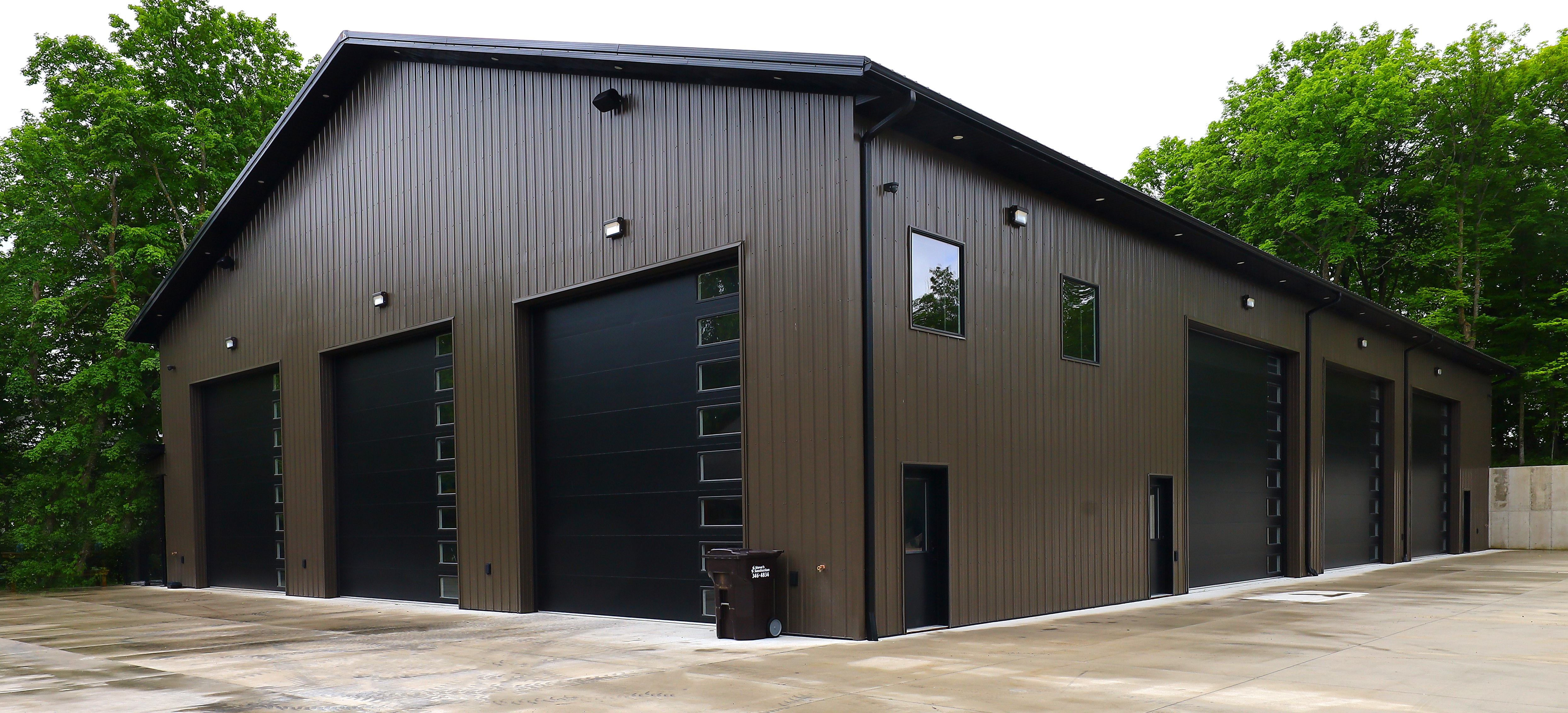 New Shop At The Lakes with multiple overhead doors and dark metal siding